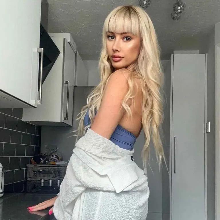 Long Blonde Hair With Wavy Curls and Blunt Bangs
