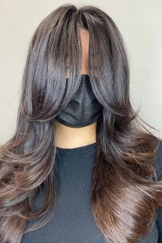 Feathered Layers with Face-Framing Curtain Bangs