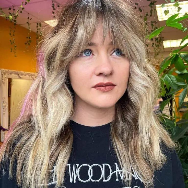 Duo-Toned Wolf Cut With Choppy Curtain Bangs on Wavy Hair and Subtle Pink Highlights