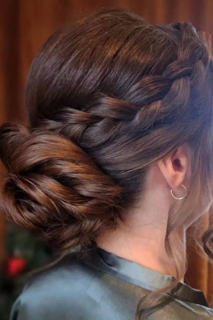 Low Plaited Brunette Bun With Wavy Tendrils