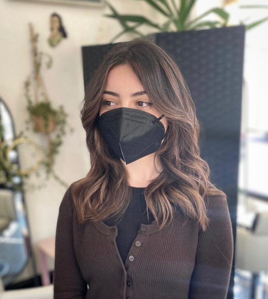 Medium Sun-Kissed Brunette Hair With 70’s Bangs
